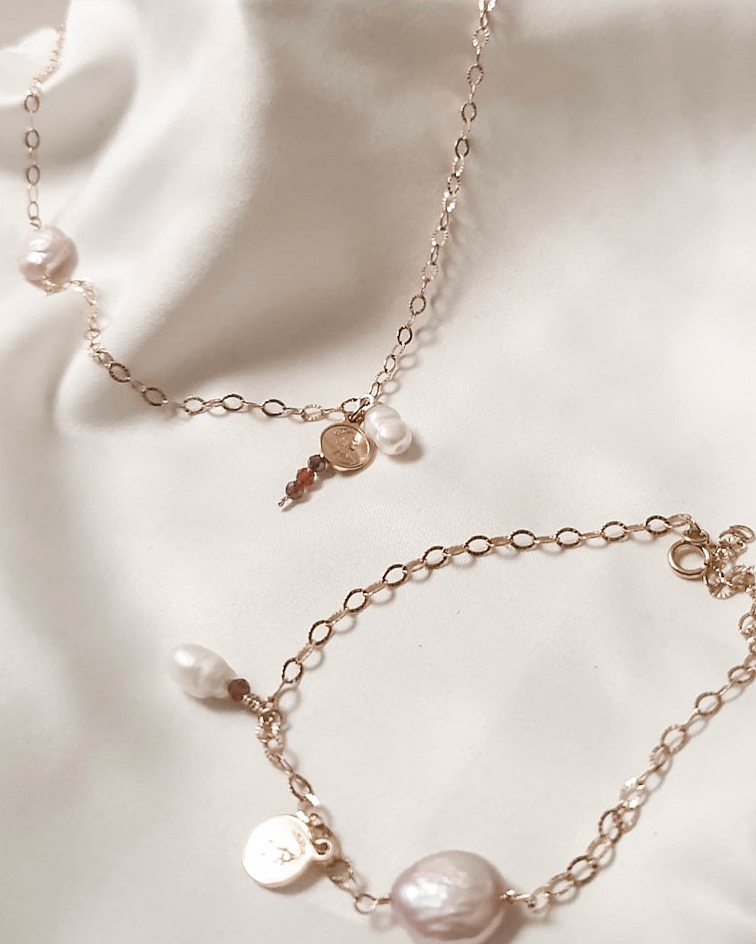 Bracelet d’or avec la perle rose, la perle blanche et la pierre de grenat